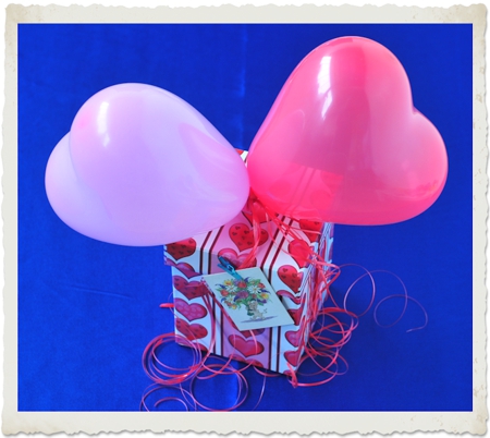 Geschenk mit kleinen Herzluftballons dekoriert
